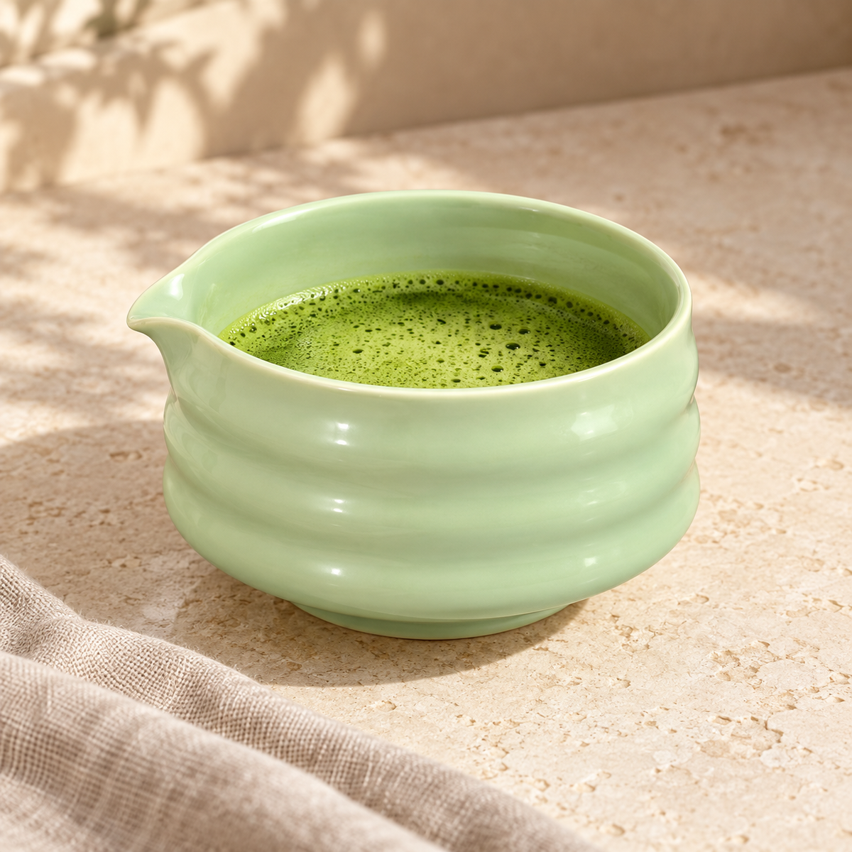Yeşil seramik chawan kasesinde hazırlanmış matcha, doğal ışıkta kullanım görünümü